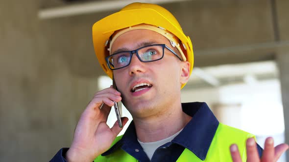 Angry Male Builder Calling on Smartphone at Office