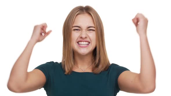 Headshot in Slow Motion of Delighted Woman Being Ecstatic About Great News Clenching Fists in alt