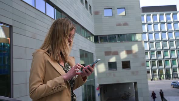 Woman Walks at City Street and Use Smartphone alt