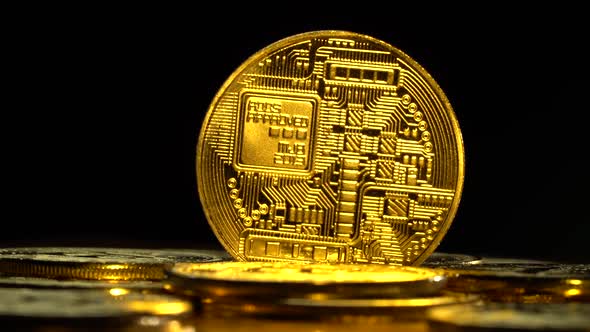 Gold Coins of Bitcoin Peer-to-peer Payment System Are Spinning on a Black Background. Close Up alt