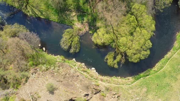 Aerial view of Mendry river in the middle of the woods. alt