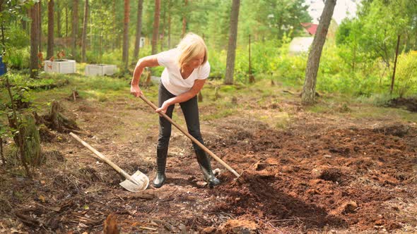 Senior Elderly Gardener Woman Digging Caring Ground Level at Summer Farm Countryside Outdoors Using