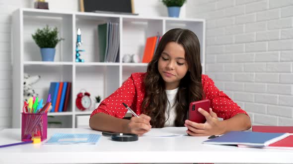 School Child Doing Homework Using Smartphone at Desk Mobile Education