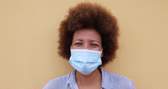 Close up of mature african woman wearing face mask for coronavirus outbreak alt