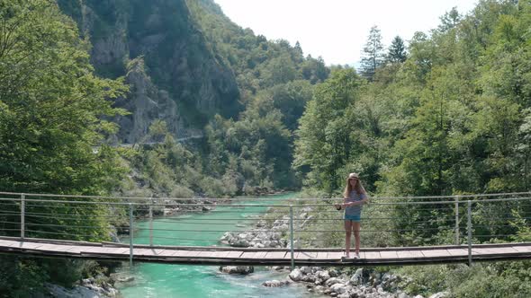 Girl standing on suspension bridge, Soca River, Soca Valley, Slovenia