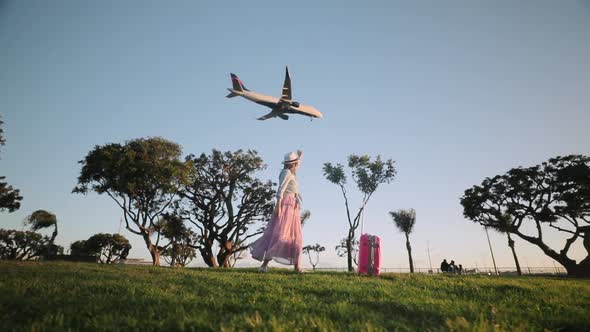 Happy Traveler Is Dancing in the Park at Sunset. Slow Motion Summer Vacation alt
