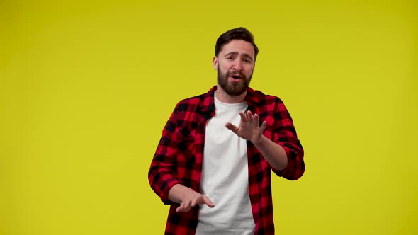 Confident Handsome Man Looks at the Camera and Laughs Boldly in the Studio on a Yellow Background alt