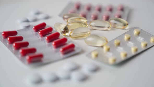 Close up of rotating pharmaceutical tablets and capsules in a blister. alt