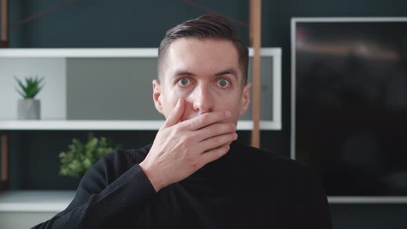 Surprised and Shocked Young Business Man in Black Sweater is Opening Her Mouth at a Loss and Looking