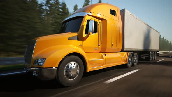 Semi truck with trailer driving through the green forest during sunny day. 4K alt