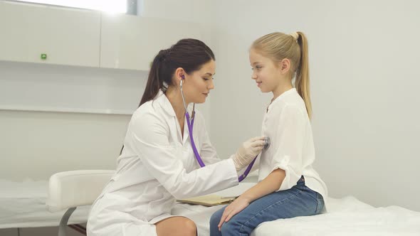 Young Doctor Pediatrician Talking with Child Girl Patient
