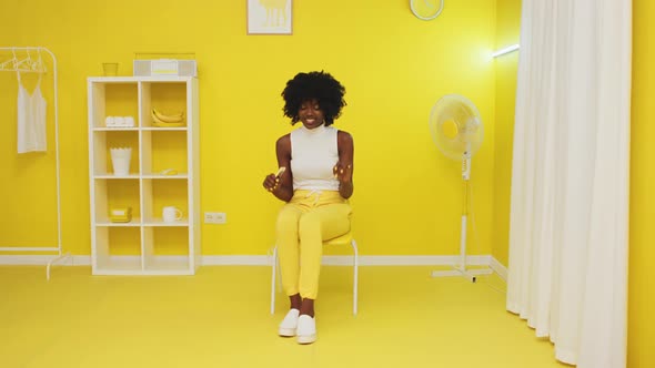 Woman Is Sitting In Yellow Room and Dancing alt