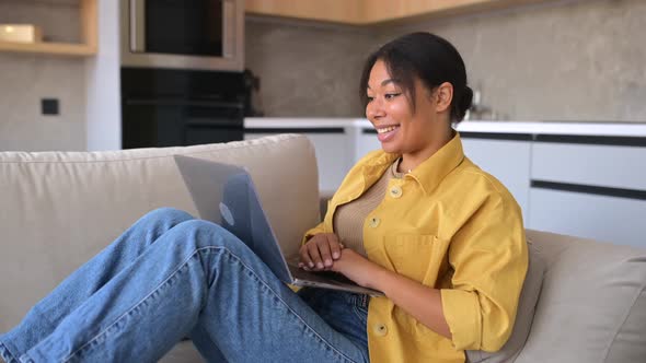 Multiracial Woman Wearing Domestic Clothes Sitting in the Living Room