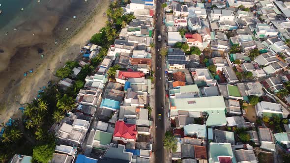 Aerial, densely packed village houses next to beach coast in Mui Ne, Vietnam alt