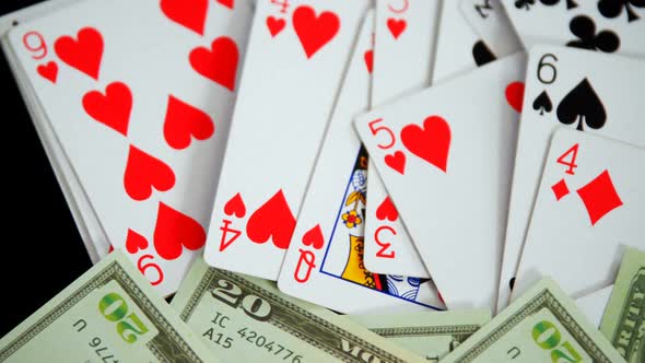 Playing cards and us dollar on poker table 4k alt