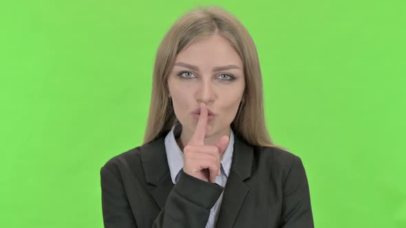Young Businesswoman Finger on Lips Against Chroma Key alt