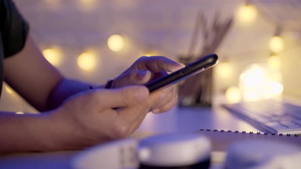 Close up shot of Female hands using smart phone in office at night