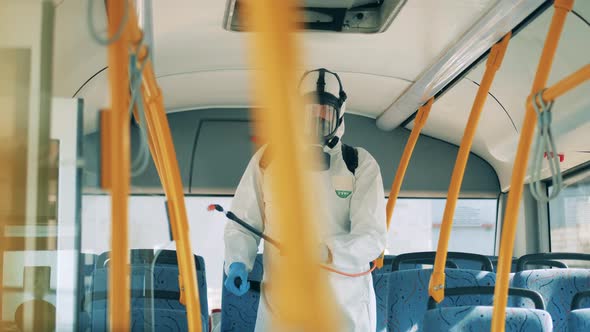 Chemical Treatment of Bus Interior Is Being Held By a Disinfector. Coronavirus Pandemic Concept alt