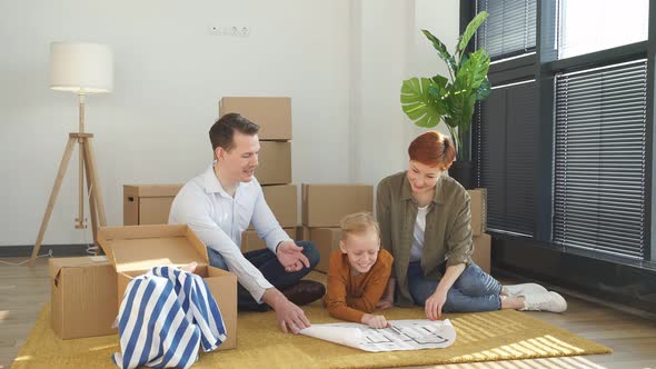 Friendly Family With Child Boy Sit On Floor Talking Planning Their Home Interior Moving Into New