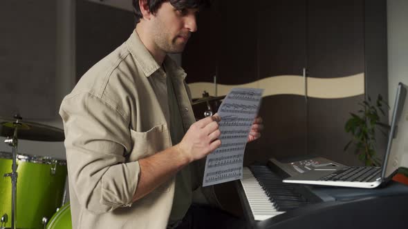 Man Gives Piano Lesson Via Laptop and Explains Concept alt