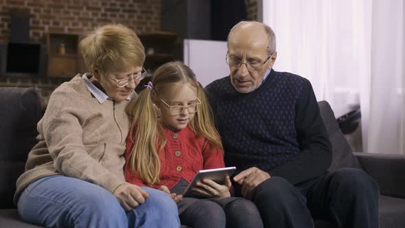 Teen Girl Teaching Grandparents To Use Touchpad alt