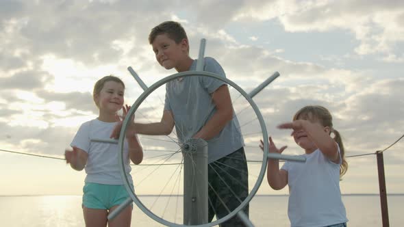 Children at the Helm of the Ship. Happy Childhood and Adventure Concept alt