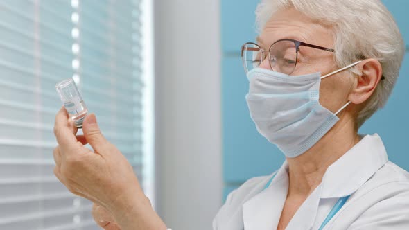 Concentrated lady doctor with protective mask fills syringe alt