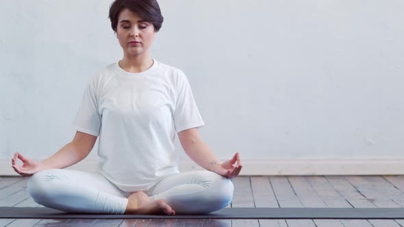Young and fit woman practicing yoga indoor in the class. alt