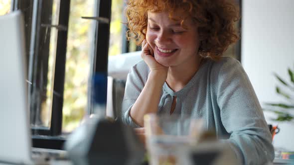 Young woman using smartphone and laptop in office alt