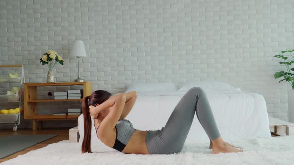 Athletic Healthy Asian woman in sportswear workout Sit up excercise at home alt