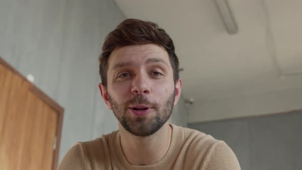 Young happy man looking at laptop by video link close-up alt