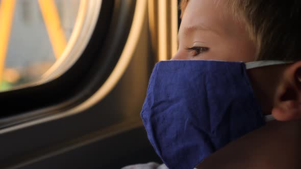 Six years old boy in protective mask travel by train. Quarantine and traveling. Back to school