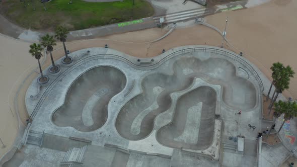 AERIAL: Close Up on Venice Beach Skate Park Empty in Morning, Cloudy Los Angeles, California  alt