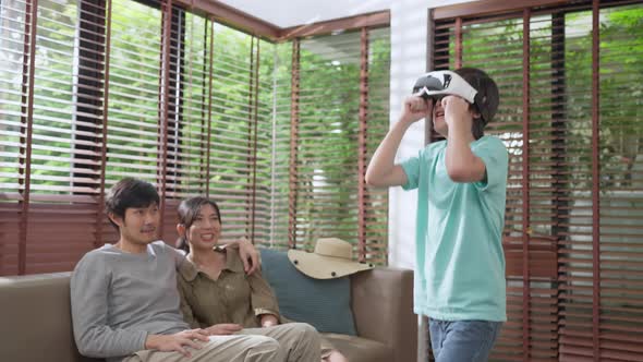 asian family son wear VR or virtual reality glasses,headsets standing and playing a video game