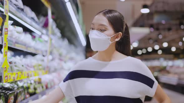 young adult asian female woman wearing protective face mask hand choosing fresh product