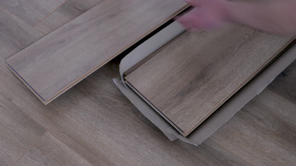 New floor laminate in hands, Wooden floor samples of laminate. Timber, laminate flooring. alt