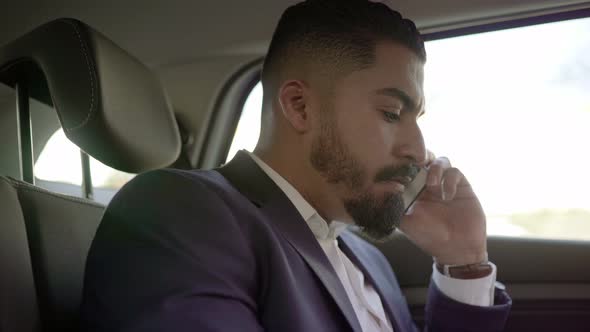 Focused Businessman Talking By Cell Phone in Car alt