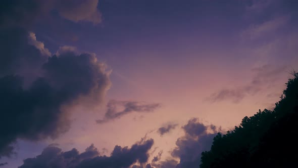 A Beautiful Timelapse with a Purple Sunset Sky and Floating Clouds with a Bright Orange Light of alt