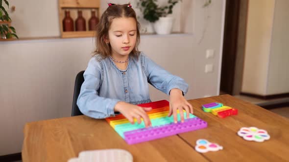 Little girl playing with big silicone popit, simple dimple, bubble fidget toy alt