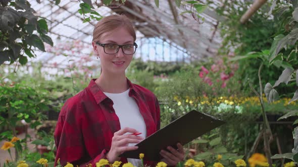 Portrait of a Young Worker of a Greenhouse in Which Flowers and Plants are Grown the Girl Inspector