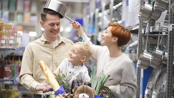 Young Joyful Family Rejoicing and Having Fun in Store