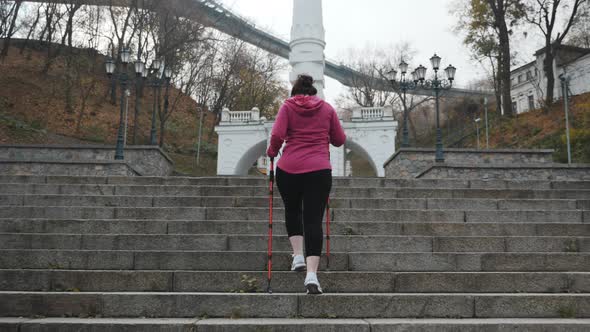 Nordic Walking. Young adult doing nordic walking exercises in city going up the stairs alt