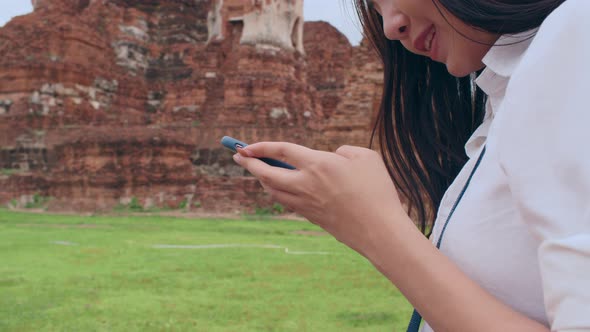 Asian backpacker blogger woman casual with camera look at photo on smartphone.