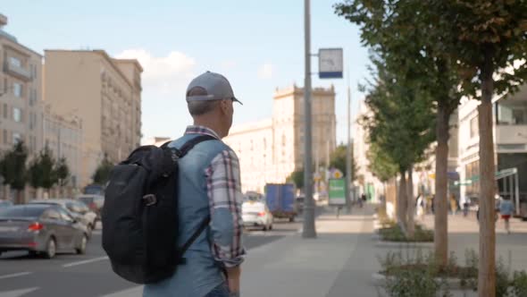 Caucasian Man Plaid Shirt Jeans Stands on Street Turns His Back Walks Away alt