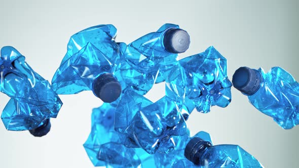 Super Slow Motion Shot of Flying Empty Plastic Bottles on Light Gradient Background alt