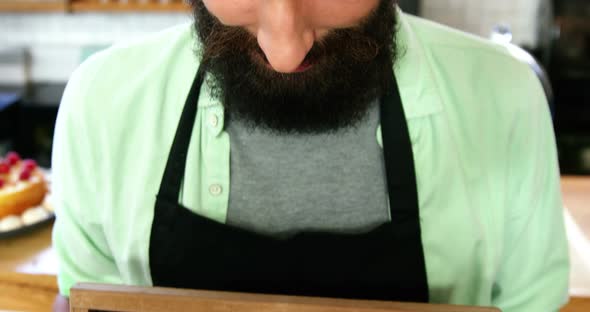 Portrait of waiter standing with open sign board alt