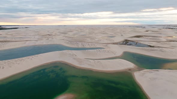 Drone Goes Backwards, Showing A Portion Of White Sand Dunes, With Bluish Water Lagoons, in Brazil