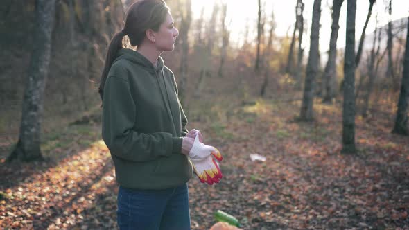 Preparation for the Collection of Garbage and Plastic Waste in the Autumn Forest. Young Woman alt