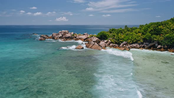 Aerial Drone View of Remote Secluded Beach with Granite Boulders Ocean Waves and Palm Trees alt