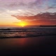 A drone flies down the coast revealing a stunning sunset at the beach - VideoHive Item for Sale